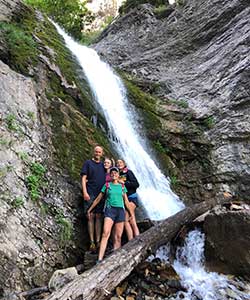 family posing by waterfall