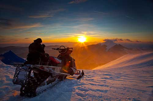snowmobile on ridge at sundown