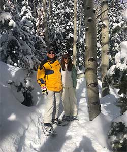 couple snowshoeing in woods